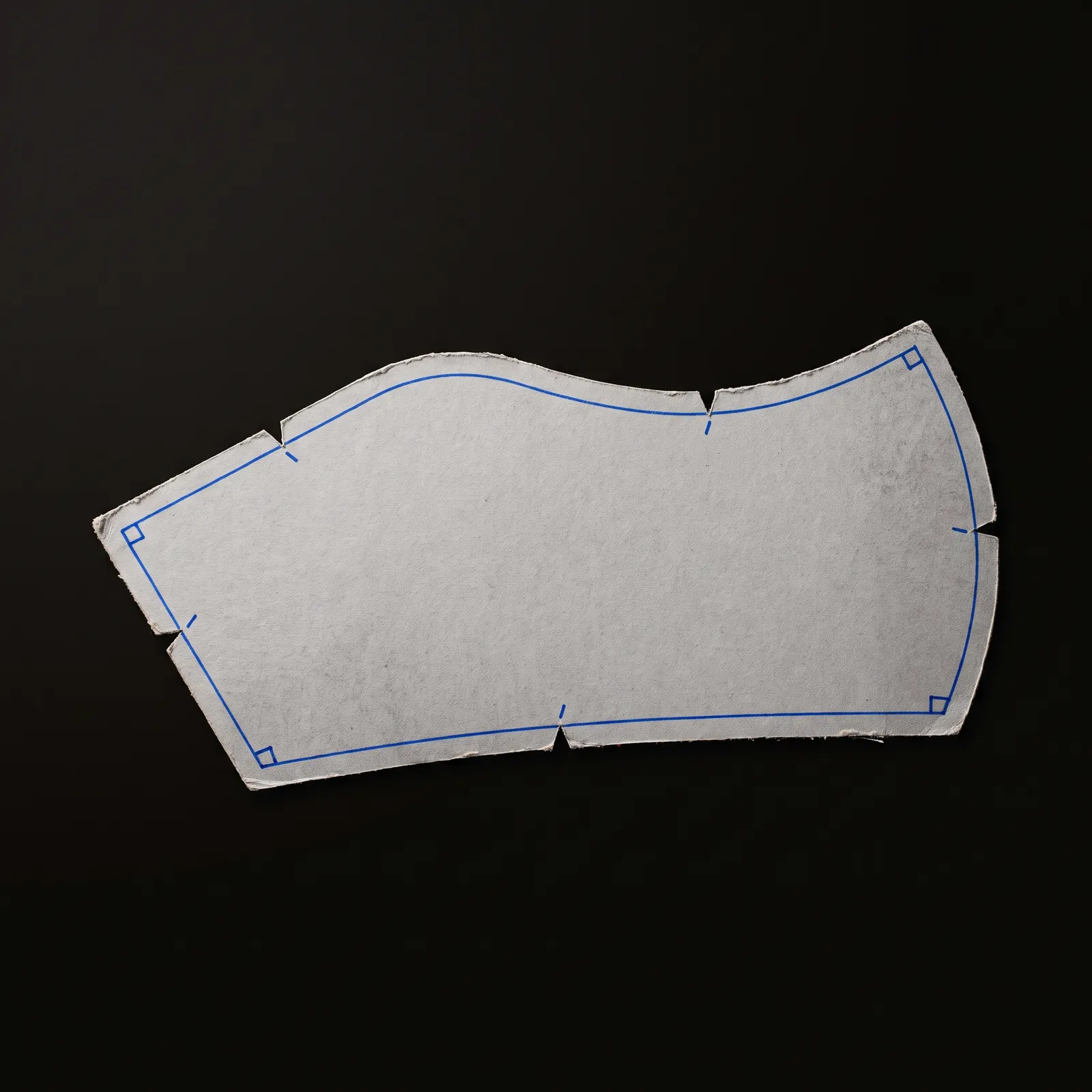 A cardboard pattern with its contour, notches and corners traced in blue.